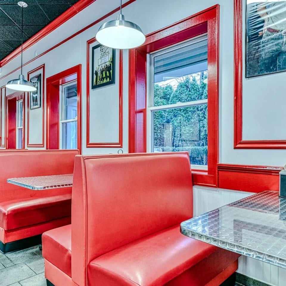 Bright red booths and chrome tables line the walls of The Burger Shop's retro-themed dining area.