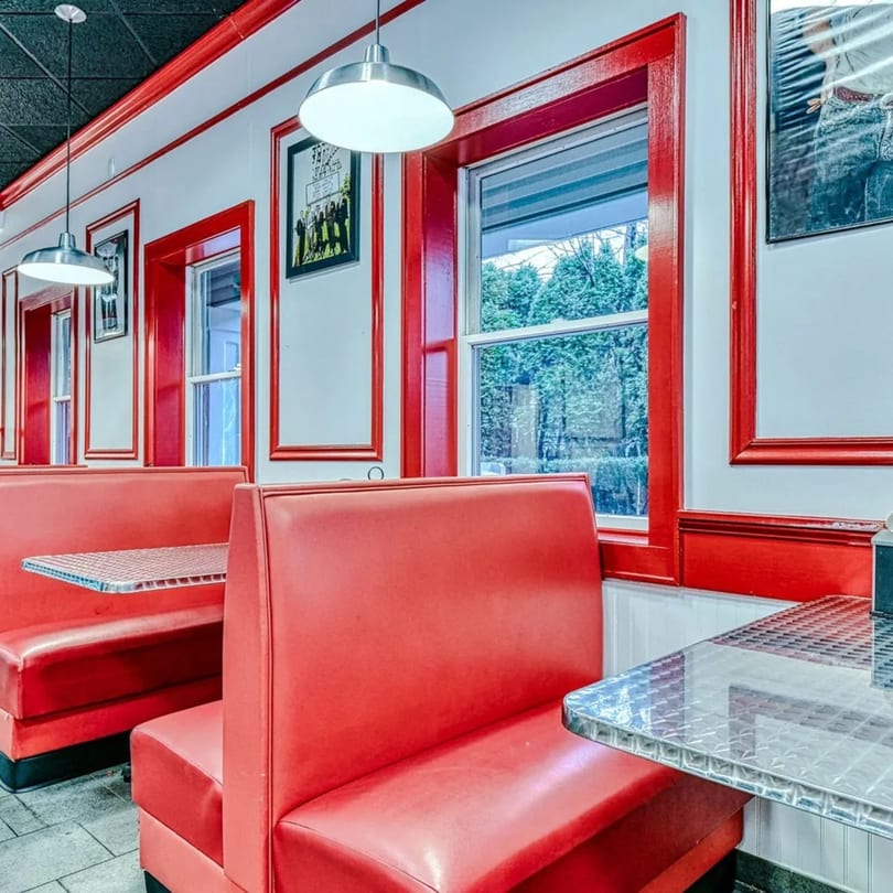 Bright red booths and chrome tables line the walls of The Burger Shop's retro-themed dining area.