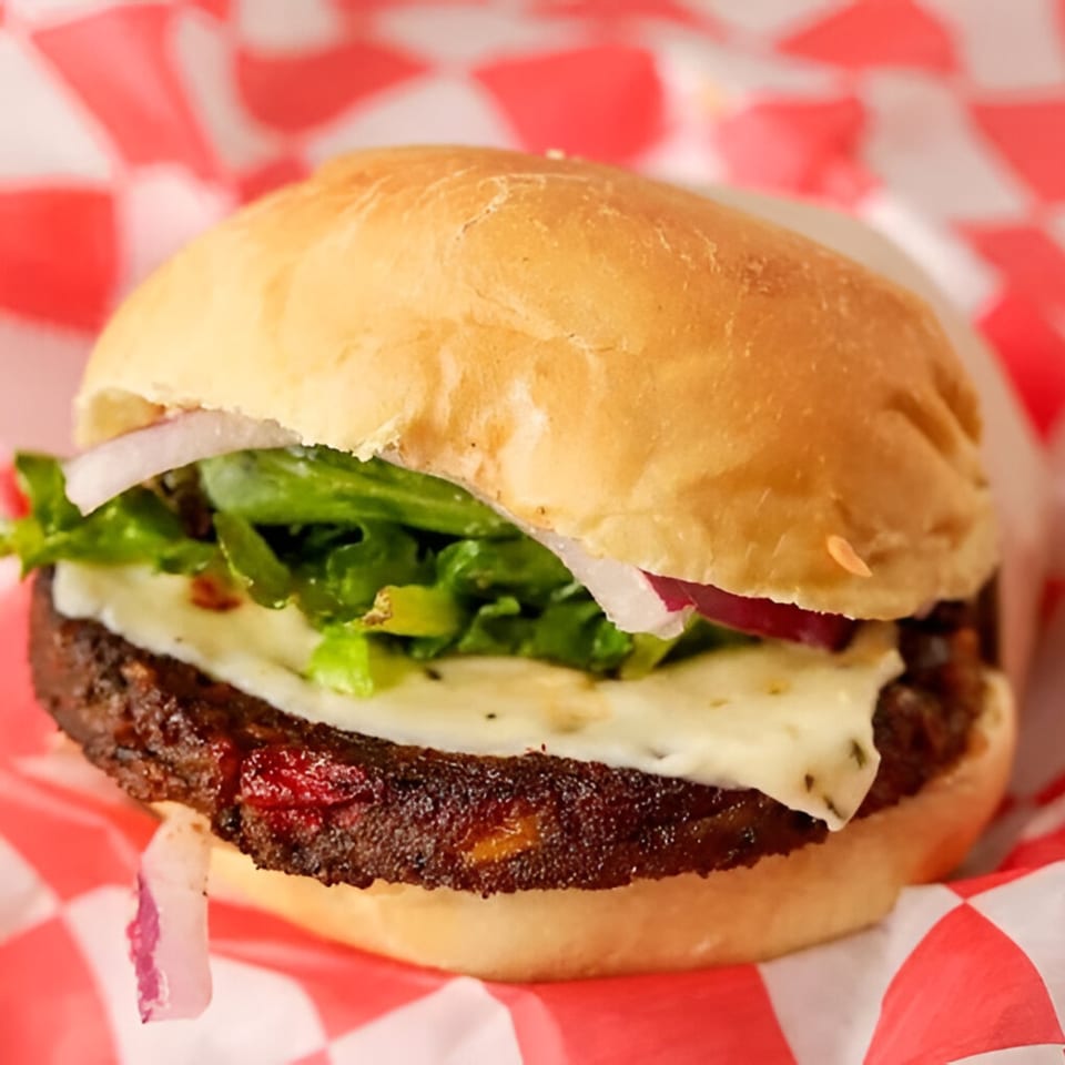 A Burger Shop burger with a thick patty, melted cheese, lettuce, and red onion on a bun.